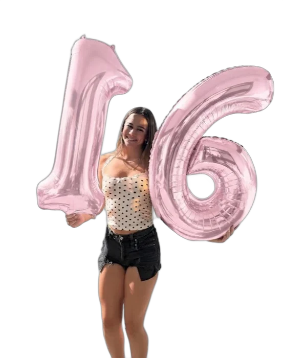 The birthday girl holding pink 1 and 6 balloons